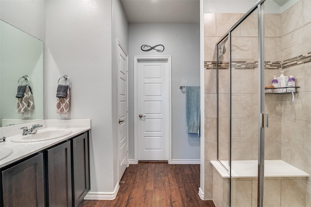 bathroom featuring vanity, wood-type flooring, and walk in shower