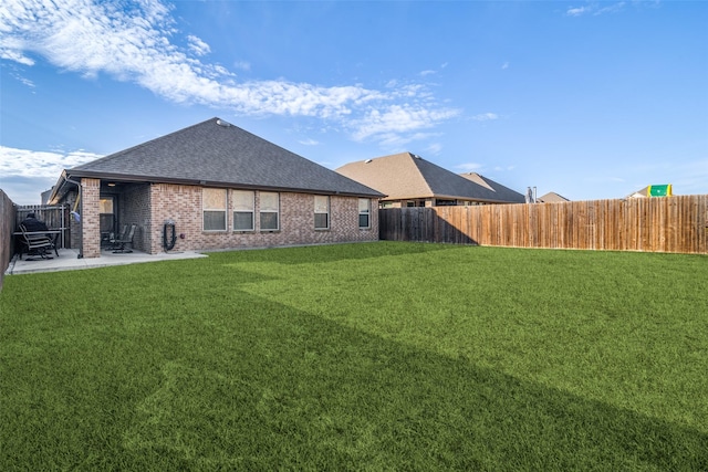 rear view of house with a yard and a patio