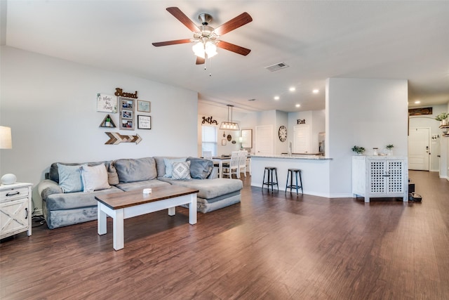 living room with ceiling fan, dark wood-type flooring, and sink