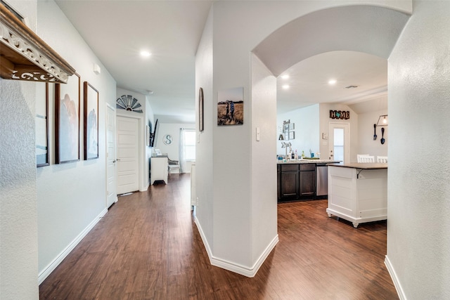 hall featuring sink, lofted ceiling, and dark wood-type flooring