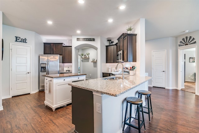 kitchen with a kitchen island, dark brown cabinetry, sink, and stainless steel appliances