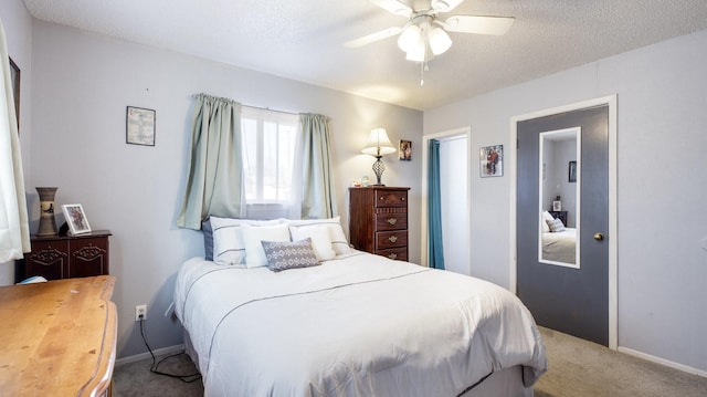 bedroom with a textured ceiling, carpet floors, and ceiling fan