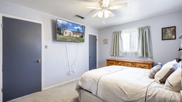 carpeted bedroom with ceiling fan and a textured ceiling