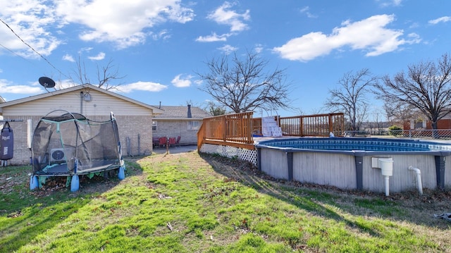 view of yard with a swimming pool side deck and a trampoline