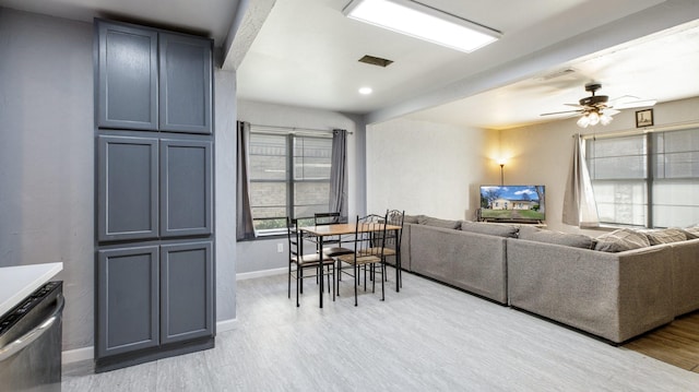 living room with beamed ceiling, ceiling fan, and light wood-type flooring