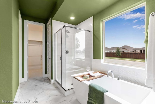 bathroom featuring shower with separate bathtub