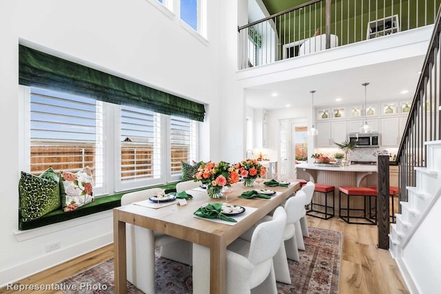 dining space with a high ceiling and light wood-type flooring