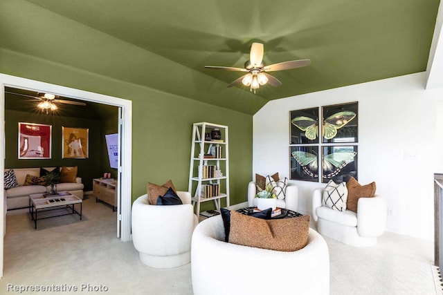 carpeted living room with ceiling fan and vaulted ceiling