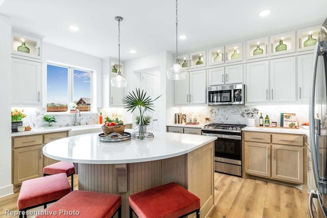 kitchen with stainless steel appliances, a kitchen island, and white cabinetry