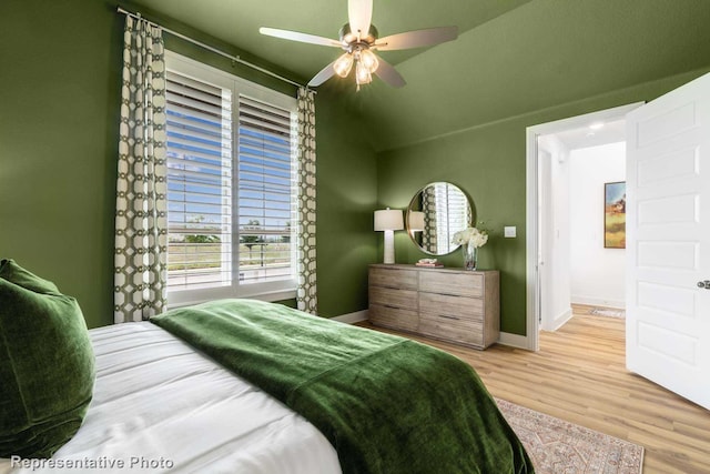 bedroom featuring ceiling fan, vaulted ceiling, and light wood-type flooring