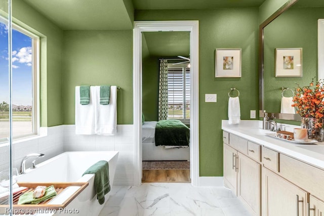 bathroom with plenty of natural light, a bathtub, and vanity