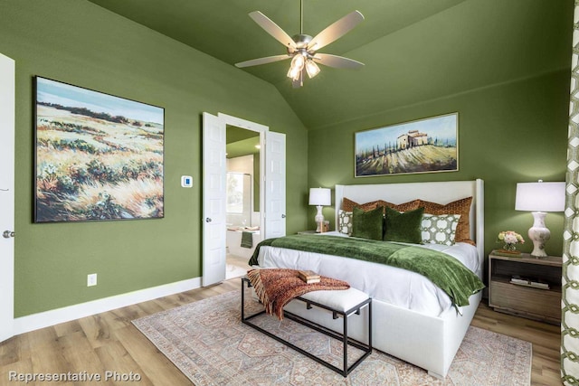 bedroom featuring ceiling fan, lofted ceiling, light hardwood / wood-style flooring, and ensuite bath