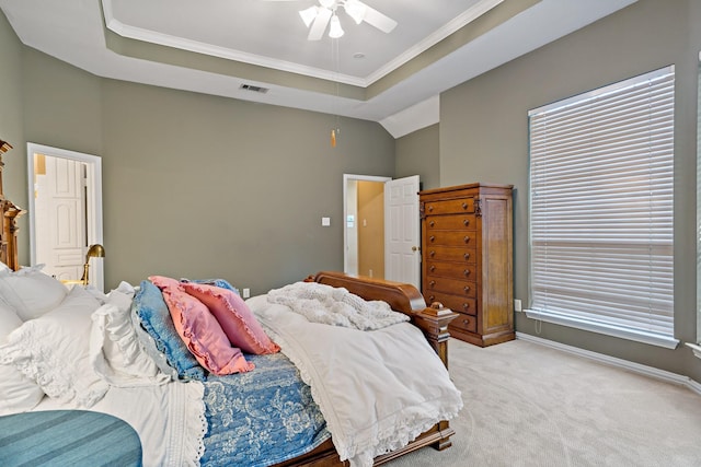 bedroom with light carpet, a tray ceiling, ceiling fan, and crown molding