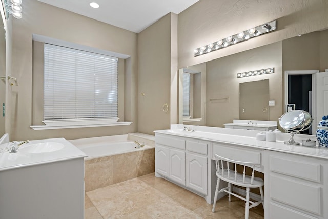 bathroom featuring tiled bath, tile patterned flooring, and vanity