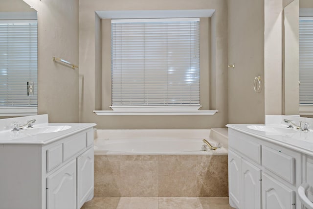 bathroom with tile patterned floors, vanity, and tiled bath