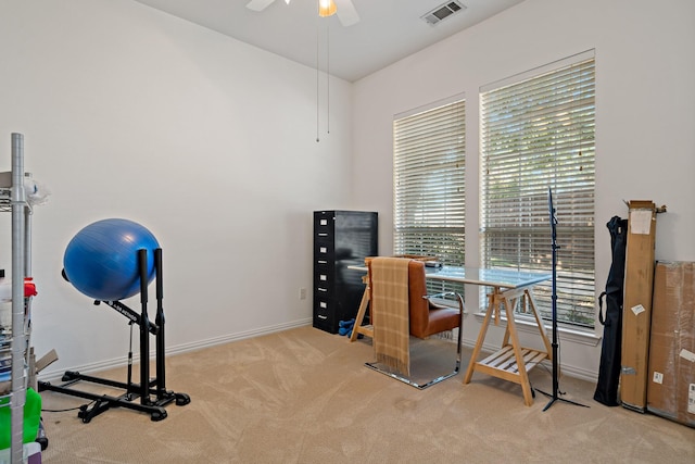 home office featuring a wealth of natural light, ceiling fan, and light carpet