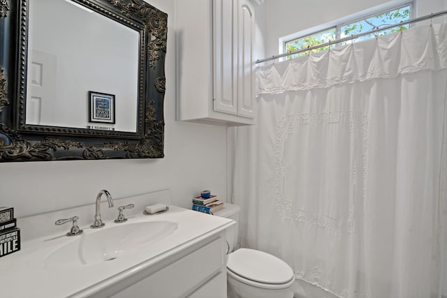 bathroom with curtained shower, vanity, and toilet