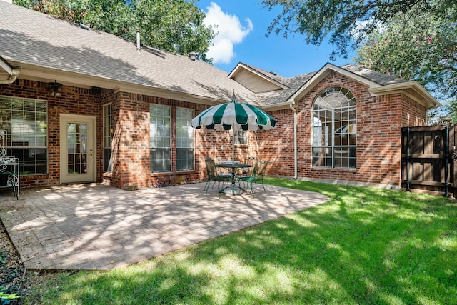 back of house with a yard and a patio