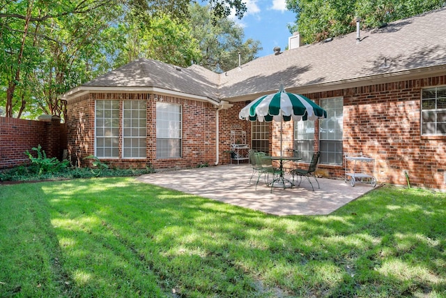 rear view of property featuring a patio area and a yard