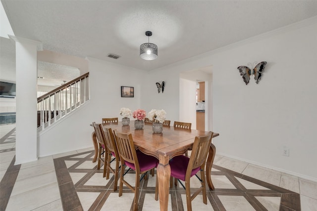 dining space featuring crown molding and a textured ceiling