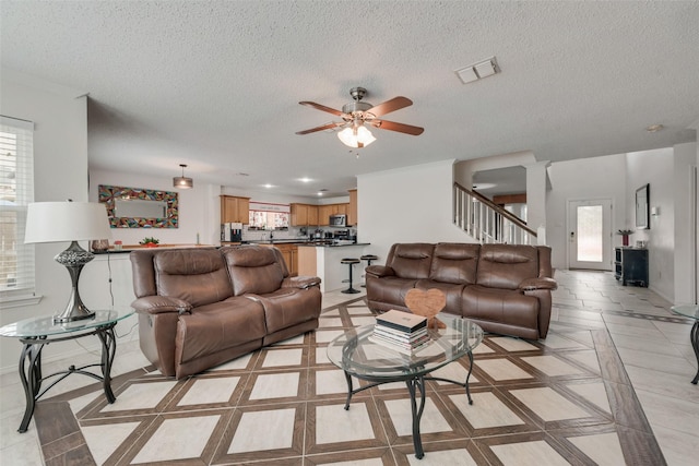 living room with a textured ceiling and ceiling fan