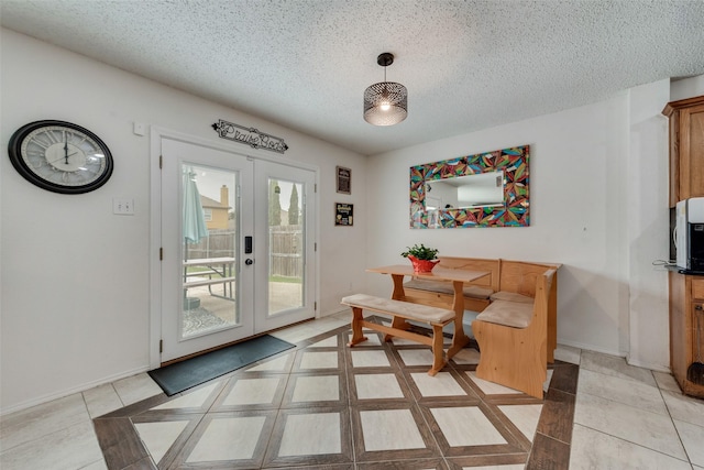 living area with light tile patterned floors, a textured ceiling, and french doors