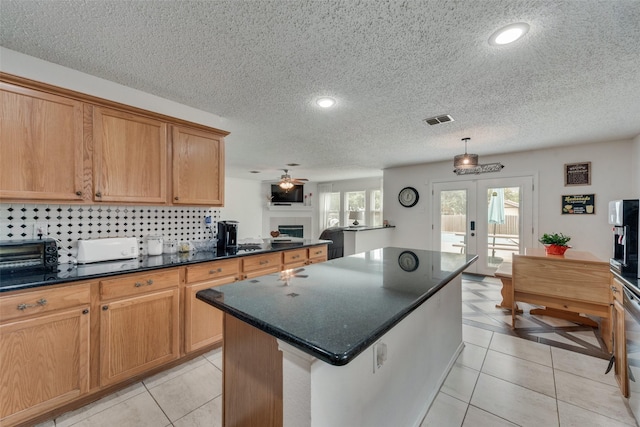 kitchen featuring french doors, a center island, a textured ceiling, light tile patterned floors, and ceiling fan