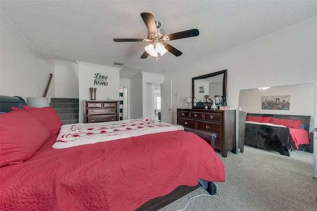 carpeted bedroom featuring crown molding, ceiling fan, a fireplace, and a textured ceiling