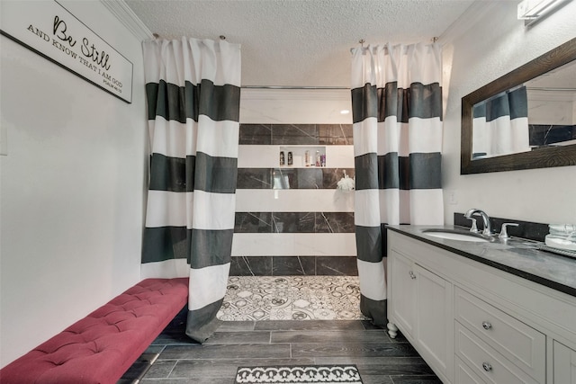 bathroom featuring vanity, crown molding, a textured ceiling, and walk in shower