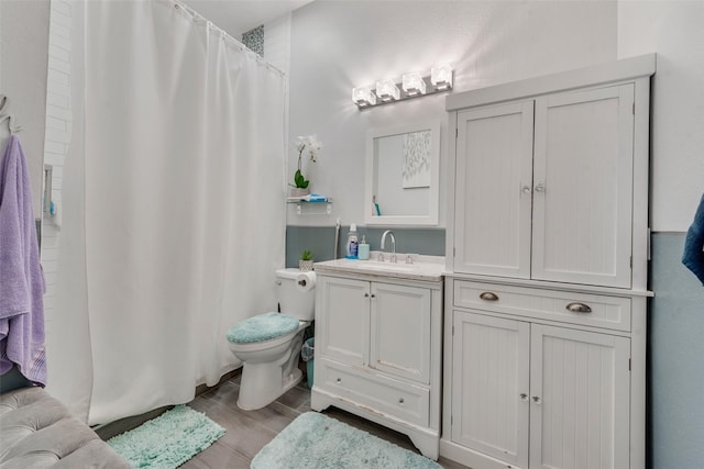 bathroom with a shower with shower curtain, vanity, toilet, and hardwood / wood-style floors