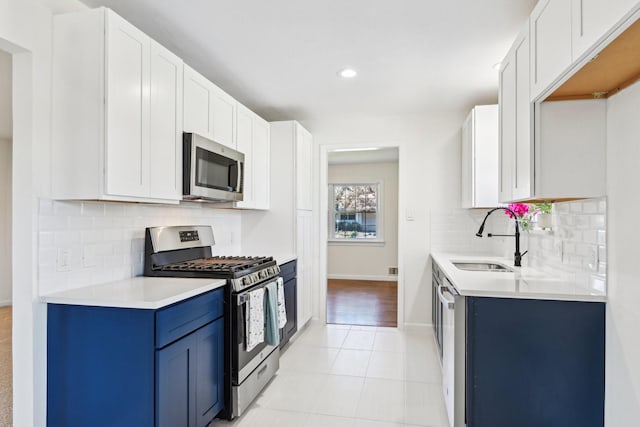 kitchen with appliances with stainless steel finishes, white cabinetry, and sink