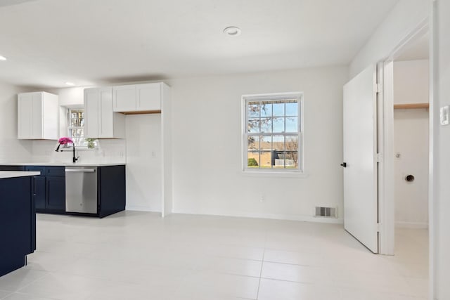 kitchen featuring decorative backsplash, white cabinetry, and dishwasher