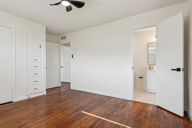 unfurnished bedroom with ceiling fan, ensuite bathroom, and dark hardwood / wood-style floors