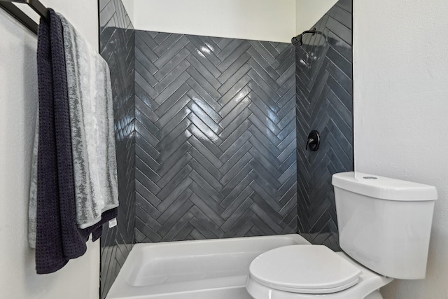 bathroom featuring toilet and a tile shower