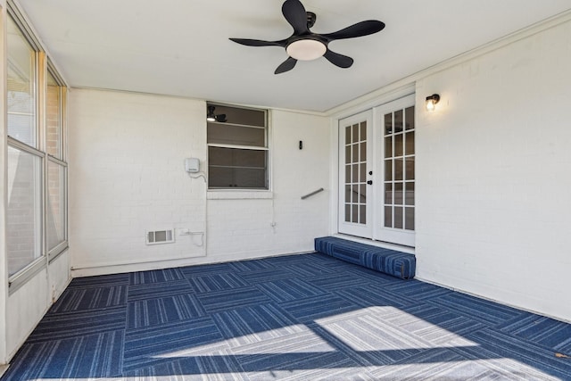 view of exterior entry featuring ceiling fan and french doors