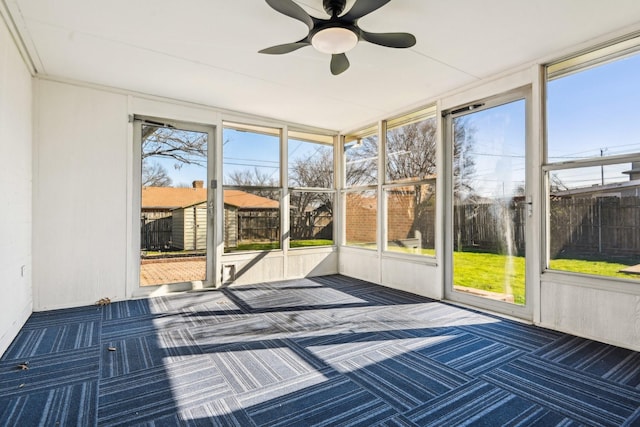 unfurnished sunroom with ceiling fan and a healthy amount of sunlight