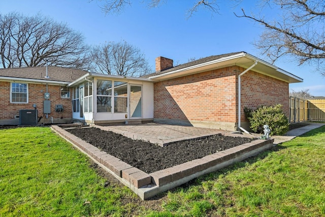 back of house featuring central AC, a yard, a sunroom, and a patio area