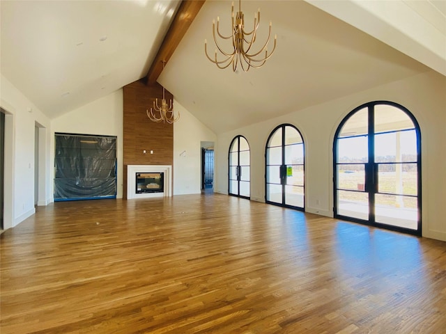 unfurnished living room featuring beamed ceiling, wood-type flooring, a chandelier, and high vaulted ceiling