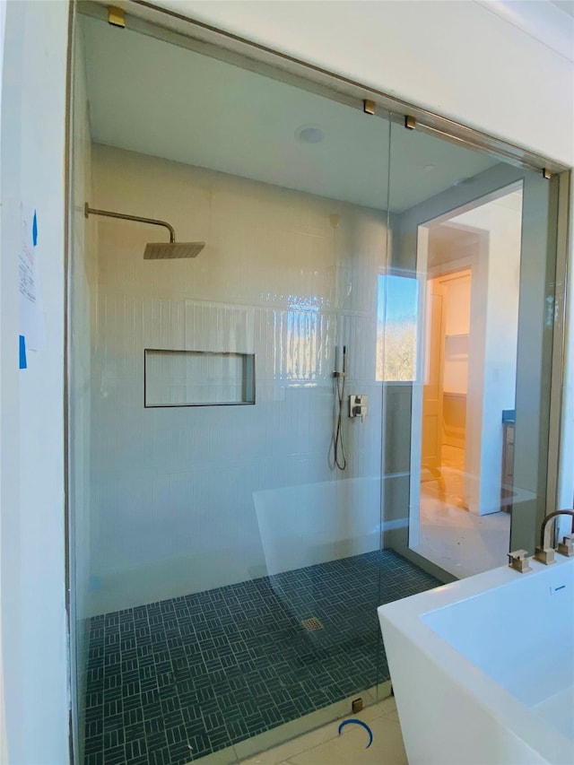 bathroom featuring tile patterned flooring, sink, and tiled shower