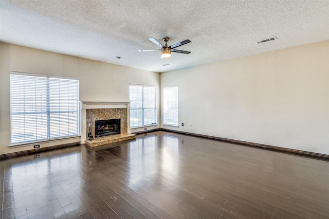 unfurnished living room featuring ceiling fan, a healthy amount of sunlight, and a textured ceiling