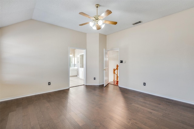 empty room featuring a textured ceiling, ceiling fan, dark wood-type flooring, and vaulted ceiling