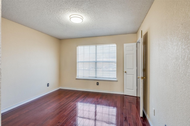 unfurnished room with dark hardwood / wood-style flooring and a textured ceiling