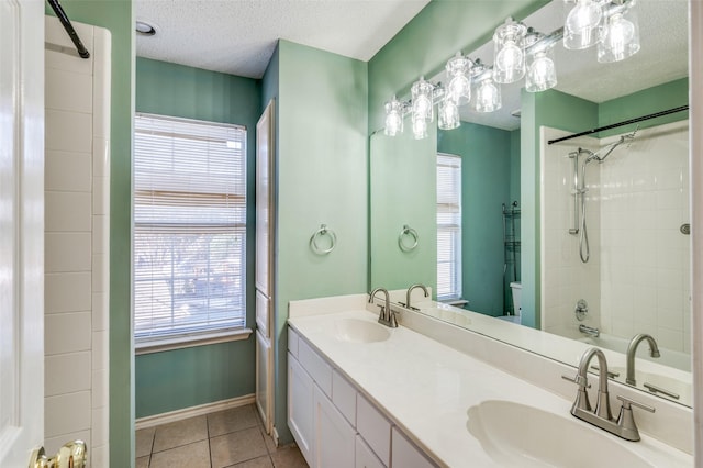 bathroom with tile patterned flooring, vanity, tiled shower / bath combo, and a textured ceiling