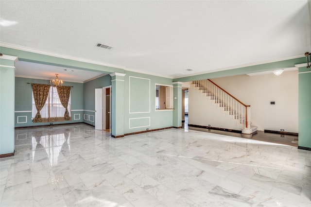 unfurnished living room with a textured ceiling, decorative columns, crown molding, and an inviting chandelier