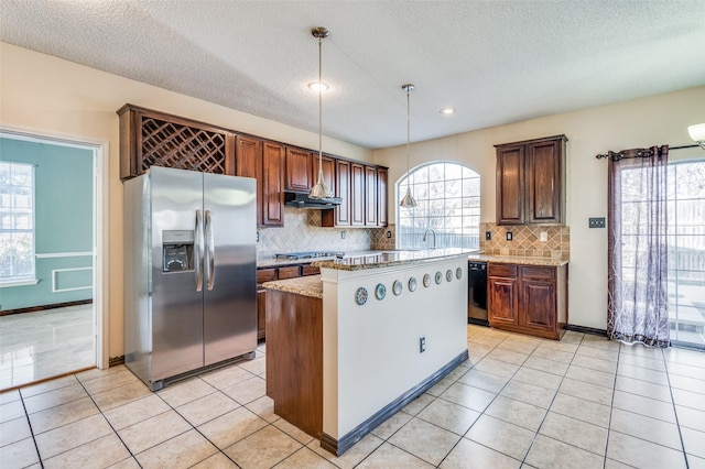 kitchen with a center island, backsplash, hanging light fixtures, a textured ceiling, and stainless steel appliances