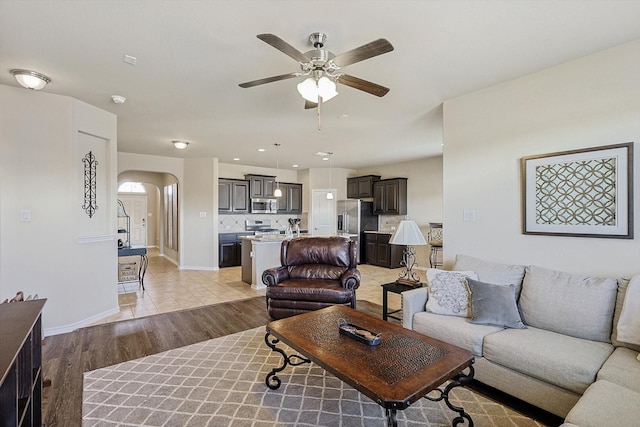 living room with ceiling fan and light hardwood / wood-style flooring