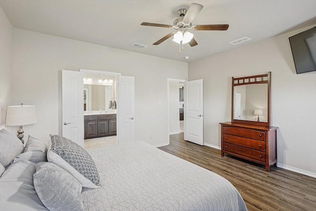 bedroom with wood-type flooring, ensuite bathroom, and ceiling fan