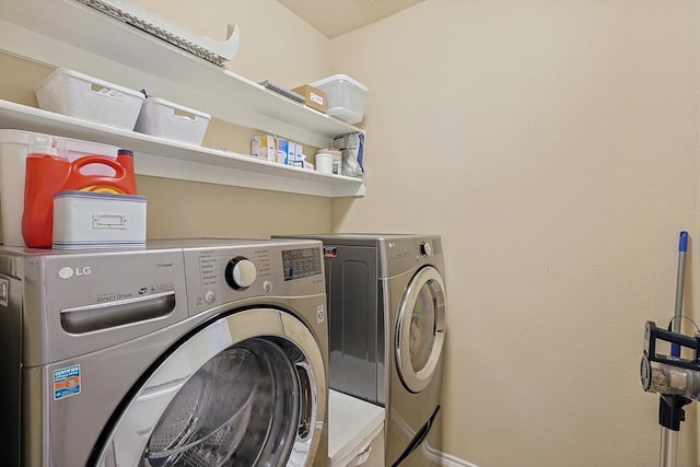 clothes washing area with washing machine and dryer