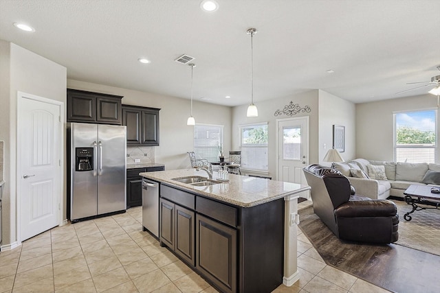 kitchen with sink, ceiling fan, an island with sink, appliances with stainless steel finishes, and light tile patterned flooring