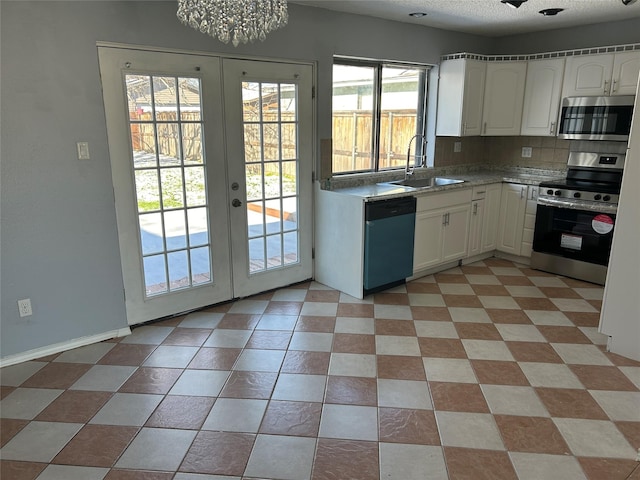 kitchen with sink, french doors, plenty of natural light, white cabinets, and appliances with stainless steel finishes